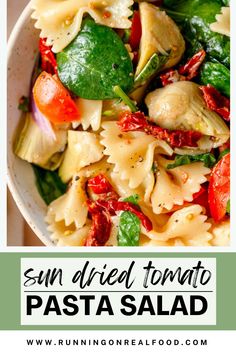 pasta salad with spinach and tomatoes in a white bowl