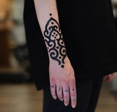 a close up of a person's hand with a tattoo on their left wrist