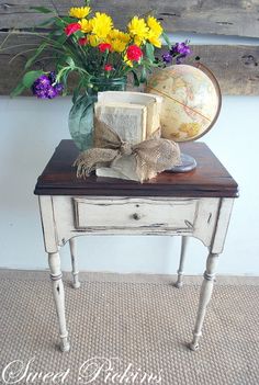 a small table with flowers and an old globe on it