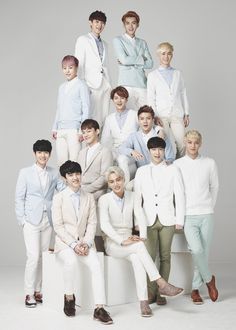 a group of young men sitting next to each other in front of a white background