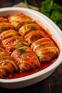 a white dish filled with ravioli covered in sauce and garnished with parsley