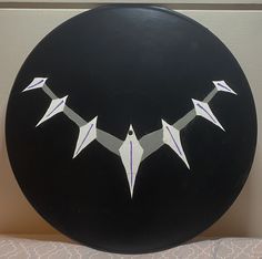 a black frisbee with white origami birds on it