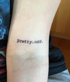 a person with a tattoo on their arm that says pretty, odd in black ink