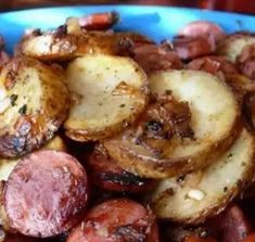 a blue bowl filled with potatoes and sausage