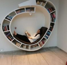 a person laying in a book shelf with books on it