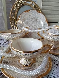 a table topped with gold and white dishes