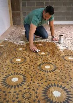 a man is working on a floor with tile in the process of being laid out