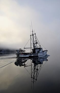 a fishing boat in the water on a foggy day