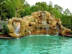 a pool with a waterfall and slide in it