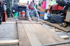 a man working on wood in a garage