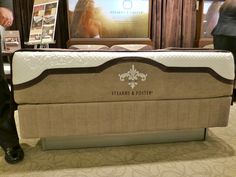 a man standing next to a mattress on display