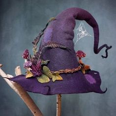 a purple witches hat sitting on top of a wooden stick