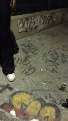 a person walking down the sidewalk with graffiti on it