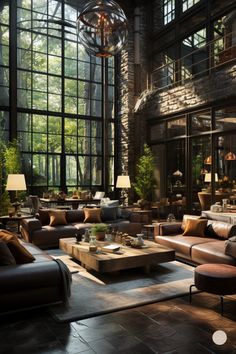 a large living room filled with lots of furniture next to tall windows and floor to ceiling windows