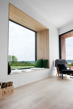 a living room filled with furniture and large windows overlooking the countryside in front of it