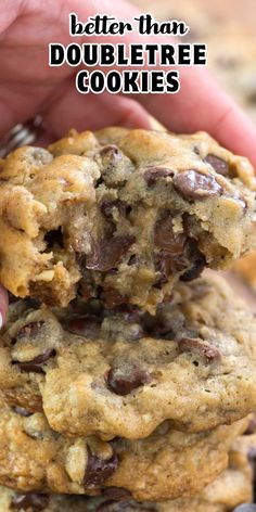 two chocolate chip cookies being held by someone's hand with the words better than doubletree cookies above them