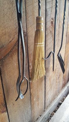 two pairs of scissors hanging from hooks on a wooden wall