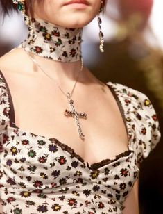 a close up of a woman wearing a necklace and choker with flowers on it