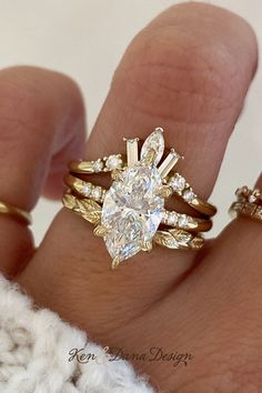 a woman's hand with two gold rings on it and a diamond ring in the middle