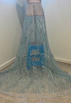 a woman's dress on display in front of a white wall with blue accents