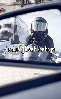 the reflection of a man wearing a motorcycle helmet in a rear view mirror that reads, i actually love biker boys