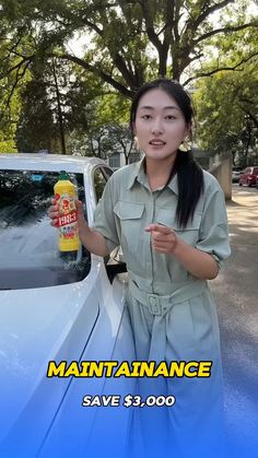 a woman standing next to a car holding a bottle of mustard