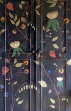 an ornately painted wooden door with flowers and leaves on the doors is seen in this image