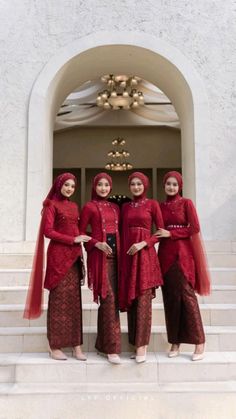 three women dressed in red standing on steps