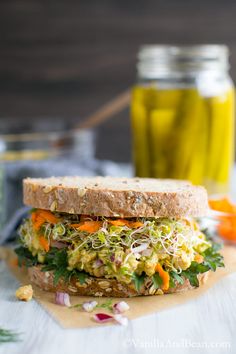 a sandwich with lettuce, carrots and sprouts