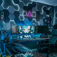 a computer desk topped with a monitor and keyboard in front of a neon wallpaper