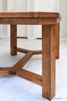 a wooden table sitting on top of a white floor next to a wall and door