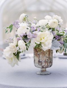 a vase filled with white and purple flowers on top of a table