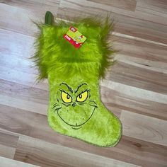 a green grin face christmas stocking on the floor