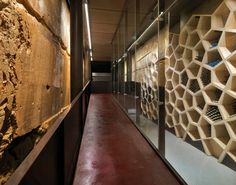 a long hallway with several shelves on the wall and one in front of it that is made out of concrete blocks