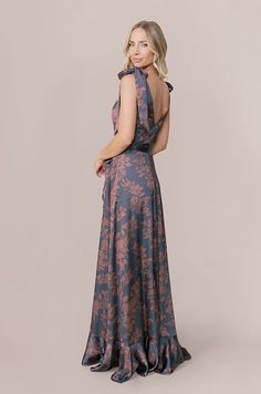 a woman in a long dress is standing with her back to the camera and looking at something