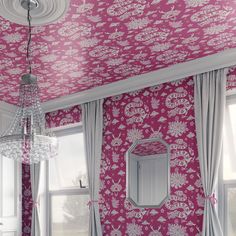 a room with pink and white wallpaper, chandelier and mirror in it