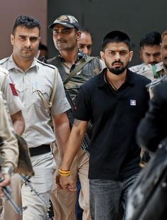 two men walking down the street with other people behind them