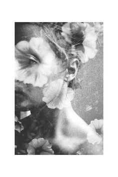 a black and white photo of a woman's face surrounded by flowers