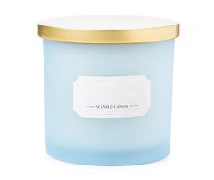 a blue candle with a gold lid sitting on a white surface, it has a label that reads scented candle