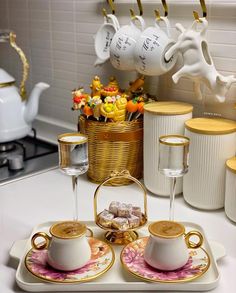 tea set with cups and saucers sitting on a tray in front of other dishes