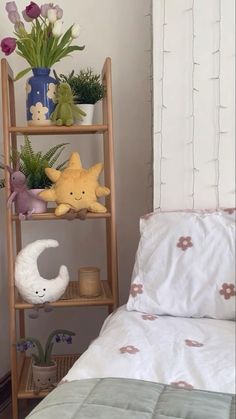 a wooden shelf filled with stuffed animals next to a bed