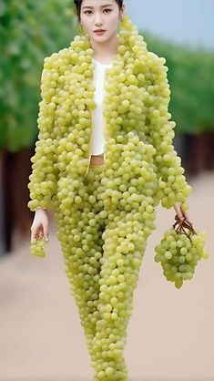 a woman is walking with grapes on her body