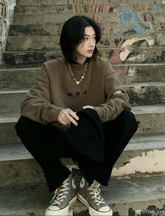 a woman sitting on the steps with her hands in her pockets