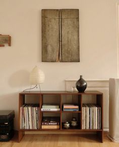 a room with a book shelf and a painting on the wall