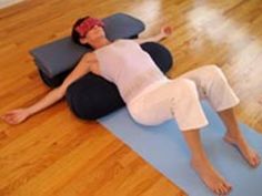 a woman is laying on a yoga mat