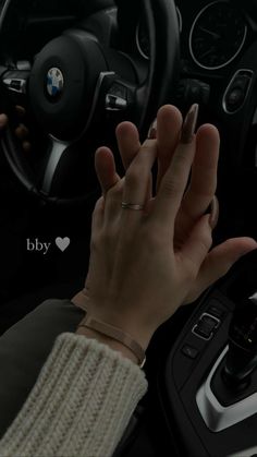 a woman's hand on the steering wheel of a car