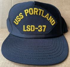 VINTAGE ! USS PORTLAND LSD-7BASEBALL CAP HAT ADJUSTABLE SIZE SNAPBACK BAND ! ONE OF THOUSANDS OF ITEMS AVAILABLE IN OUR EBAY STORE!  ITEM:  ONE (1) BASEBALL CAP LOGO: USS PORTLAND LSD-7 MANUFACTURER: UNKNOWN, MADE IN USA COLOR:  NAVY BLUE HAT SIZE:  ADJUSTABLE SNAP BACK BAND DESCRIPTION: This is a VINTAGE, NEW WITHOUT TAGS baseball cap! Acrylic. Billboard style front. Embroidered ship name and hull number in yellow on blue patch. Adjustable size. A wonderful addition to your hat collection! COND Vintage Navy Snapback Baseball Cap, Vintage Navy Cap Hats, Navy Vintage Cap Hat, Vintage Navy Snapback Hat With Flat Bill, Vintage Navy Cap, Vintage Navy Snapback Hat, Navy Retro Snapback Baseball Cap, Navy Blue Hat, Cap Logo