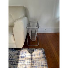 a white couch sitting next to a table on top of a hard wood floor in a living room