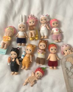 a bunch of small toy figurines sitting on top of a white bed sheet