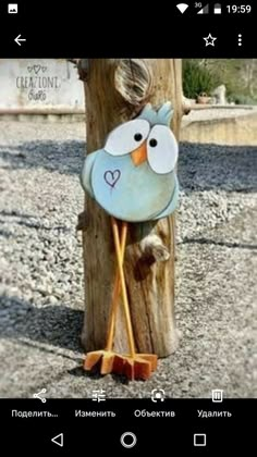 a wooden pole with a bird painted on it's face and two orange legs